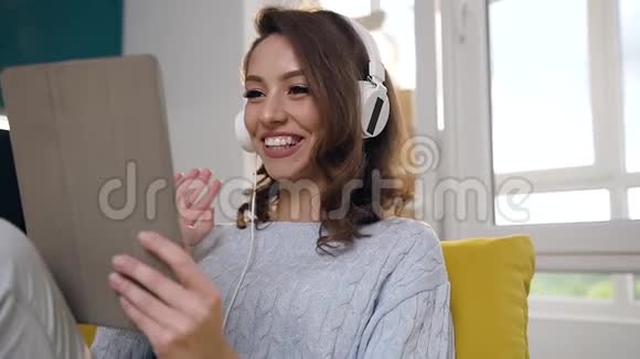 带着耳机用笔记本电脑对她的网络对话者说hallo笑得很开心视频的预览图