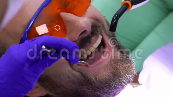 牙医使用一种特殊的紫外线灯来保护牙齿填充物视频的预览图