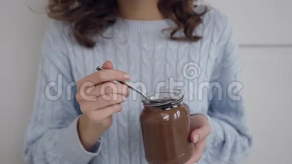 迷人的卷发微笑女士享受美味的巧克力坚果与梦幻般的闭眼视频的预览图