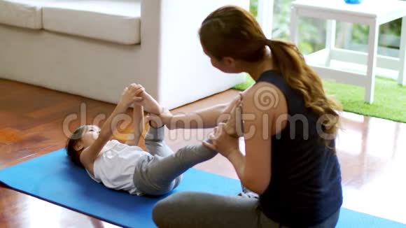可爱的女儿和她的母亲一起快乐地做基础瑜伽运动视频的预览图