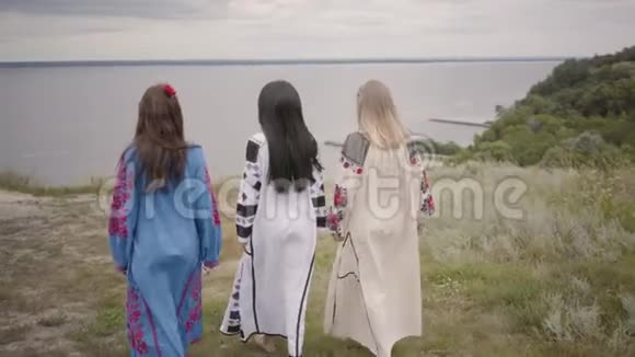 后景三个女朋友穿着漂亮的长夏装刺绣走向河边概念视频的预览图