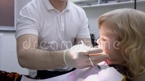 小孩张开嘴让牙医检查他的牙齿视频的预览图
