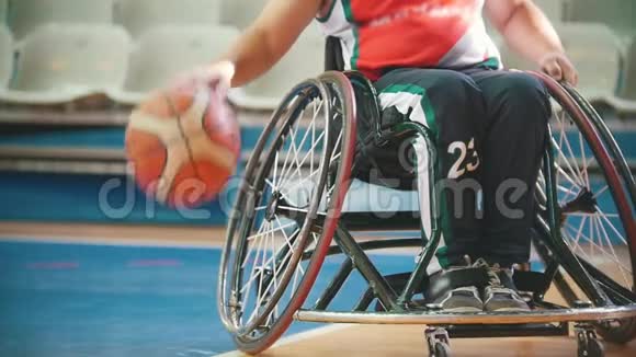 残疾人轮椅篮球运动员练习在运动场上打球视频的预览图
