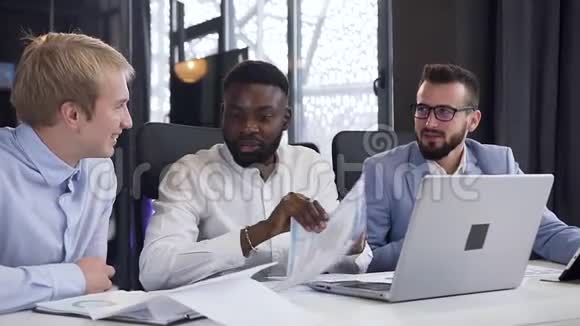 30多岁的多种族男性同事在他们的联合项目下与财务文件一起工作视频的预览图