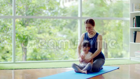 年轻的母亲教她可爱的女儿锻炼身体视频的预览图