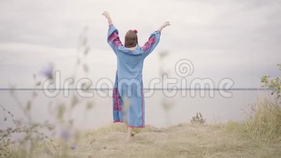 美丽的赤脚年轻的黑发女孩的后景红色的头发和美丽的蓝色长夏礼服视频的预览图