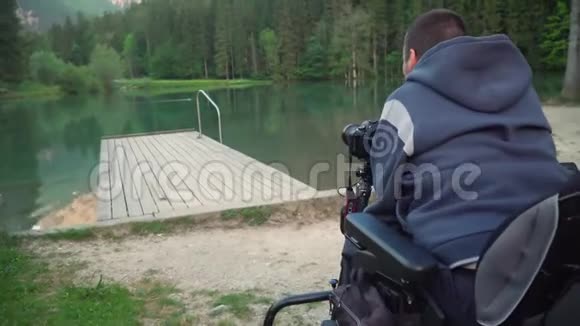 4k分辨率视频一名男子用dslr相机拍摄美丽的湖和山的背面视频的预览图