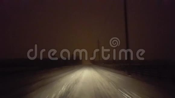 夜间在农村路雪暴雪中驾车司机视角POV厚重风暴雪和雪花视频的预览图
