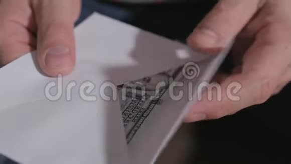 一个男人的手特写从一个纸信封里掏出许多百元钞票视频的预览图