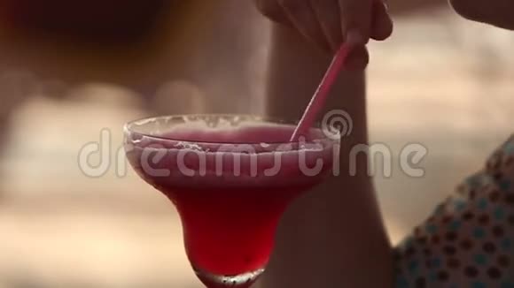 日落时分喝红鸡尾酒的女人视频的预览图