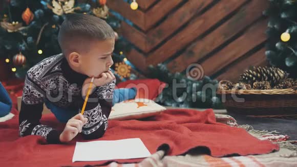 4K视频体贴的男孩寻找一些东西写在一封信给圣诞老人但他不知道视频的预览图