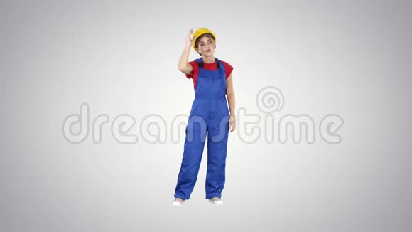 疲惫的女人穿着建筑服装经过艰苦的工作日在梯度背景下视频的预览图