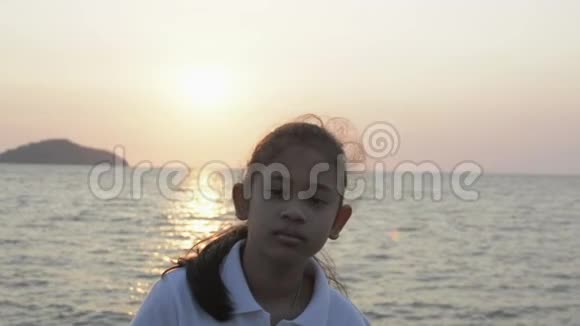 亚洲可爱女孩站在海岸美丽风景的肖像视频的预览图