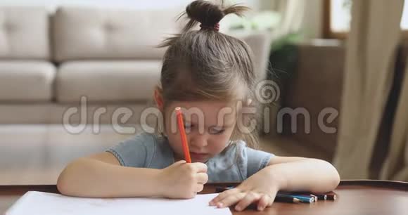 专注的可爱的女孩独自玩铅笔画画视频的预览图