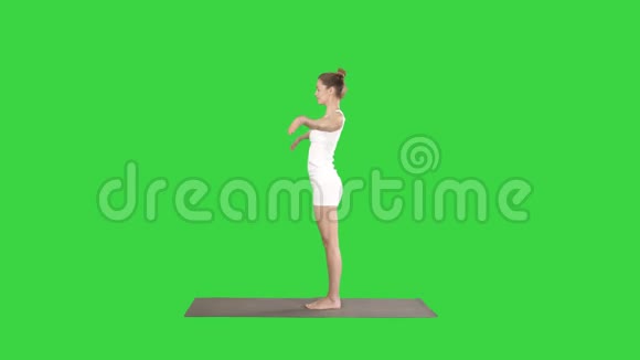 美丽的模特做瑜伽运动站在Uttanasana手掌在脚踝后面的绿色屏幕上Chroma视频的预览图