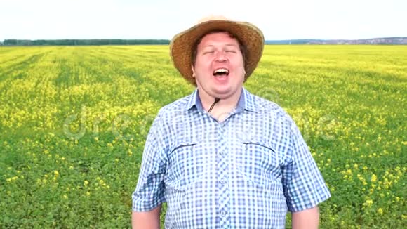 在阳光明媚的日子里站在田野里欢笑的快乐农夫的画像视频的预览图