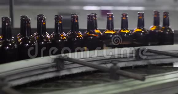 清洁玻璃棕色瓶正在沿着生产线在生产工厂移动视频的预览图