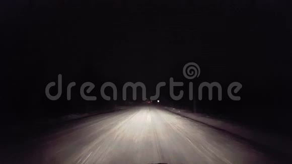 夜间在农村路上下雪时开车冬季的POV雪和雪花的司机视角视频的预览图