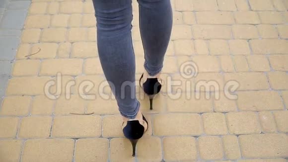 女人的腿穿着高跟鞋走在路上慢动作视频的预览图