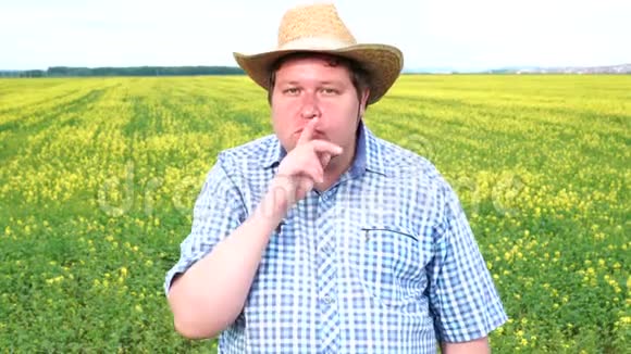 农夫站在田野里在阳光明媚的日子里做着沉默的手势视频的预览图