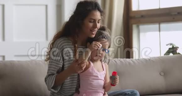 快乐的妈妈和小女儿在家吹肥皂泡视频的预览图