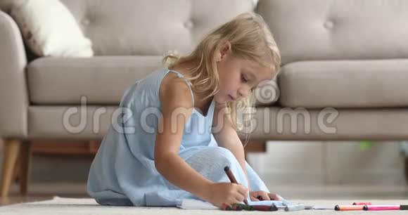 可爱的女孩在地板上用毛毡笔画画视频的预览图