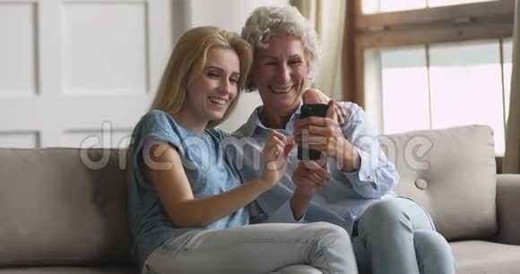快乐的老妈妈和成年女儿在电话里自拍视频的预览图
