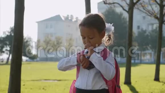 一个穿校服的小女孩站在智能手表上说话视频的预览图