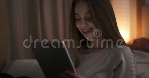 晚上玩数字平板电脑的少女视频的预览图