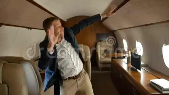 快乐自信的商人在豪华飞机里跳舞视频的预览图