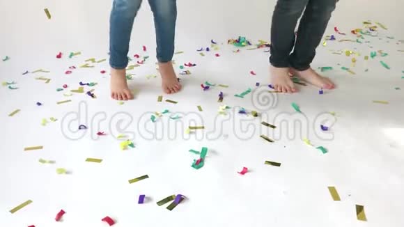 孩子们脚跳在铺有彩色纸屑的地板上视频的预览图