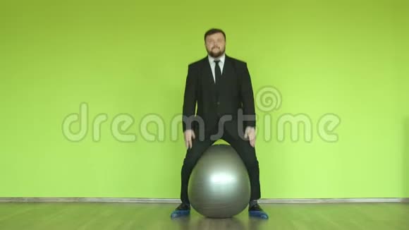 胡子胖子办公室职员在绿色背景下跳健身球色度键视频的预览图