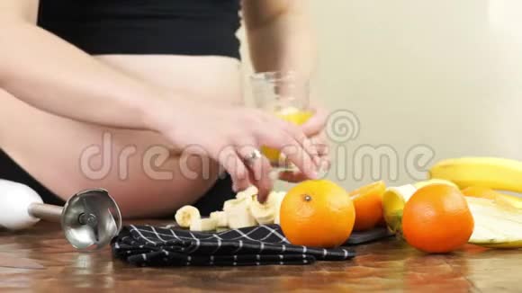 怀孕三个月的孕妇准备一些新鲜的橙汁制成健康的水果奶昔视频的预览图