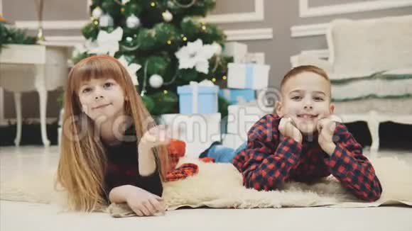 年轻的双胞胎兄弟姐妹高兴地祝贺大家在圣诞节的早晨视频的预览图