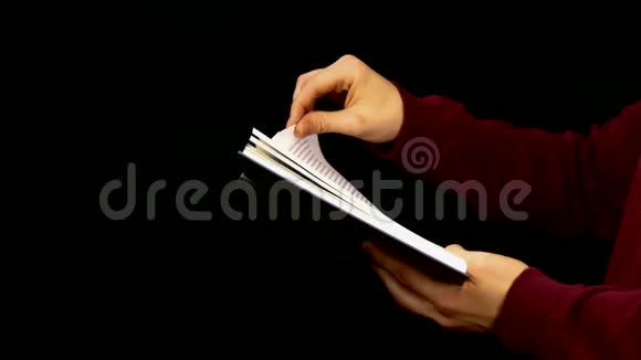 男性手滑翻黑底书页视频的预览图