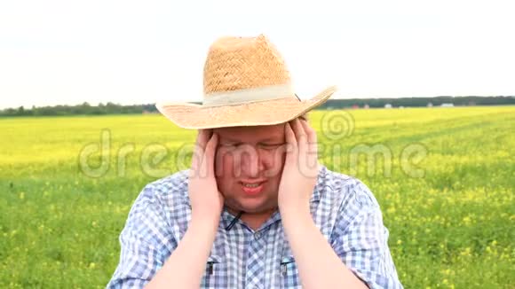 特写悲伤的年轻农民带着忧虑的紧张表情戴牛仔帽的人头痛视频的预览图