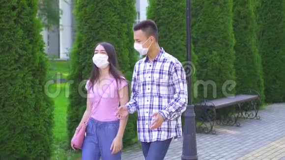 两个戴着医用口罩的年轻亚洲学生走在街上慢吞吞地说着视频的预览图