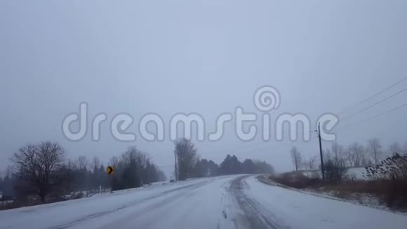 冬季暴风雪期间在公路转弯处上坡行驶司机的观点POV雪雪暴雪视频的预览图