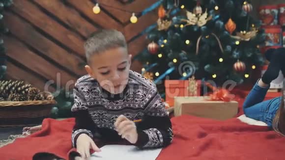 4K视频体贴的男孩寻找一些东西写在一封信给圣诞老人但他不知道视频的预览图