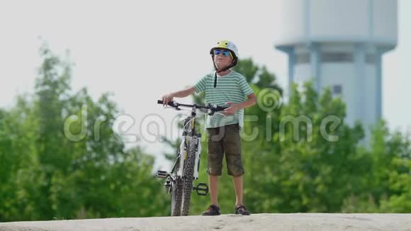 男孩手里拿着一辆山地自行车开始用自行车移动视频的预览图