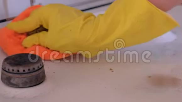 女人手戴黄色橡胶手套在厨房洗脏煤气炉视频的预览图