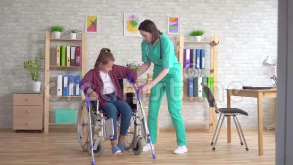护士帮助残疾女孩在受伤后从轮椅上站起来视频的预览图