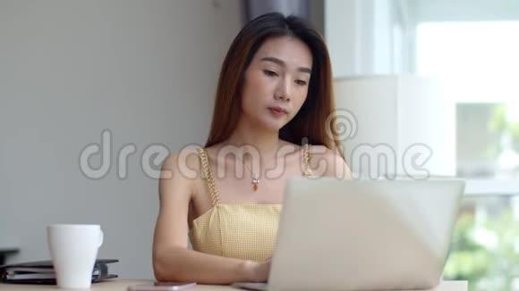 年轻漂亮的女人在咖啡店里用笔记本电脑工作视频的预览图