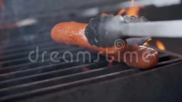 美味多汁的香肠烤火厨师在烤架上准备香肠扔在烤架上翻过来视频的预览图