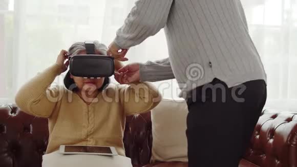戴着虚拟现实眼镜的老人与妻子玩游戏视频的预览图