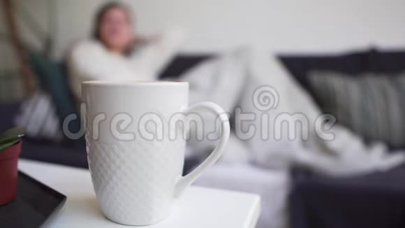 拉格姆概念女孩喝一杯白咖啡站在桌子上喝一杯热饮料享受简单和简单视频的预览图