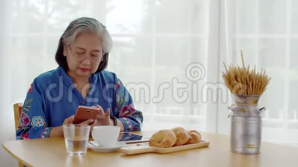 高级女性使用智能手机支付QR代码视频的预览图
