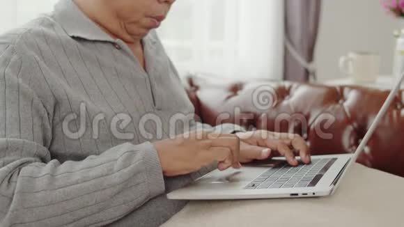 老人在家里用笔记本电脑打字聊天视频的预览图