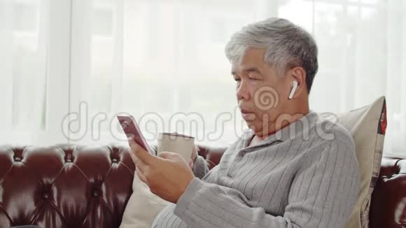 老人用无线耳机听音乐喝咖啡视频的预览图