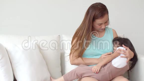 年轻的母亲用温度计检查女儿视频的预览图
